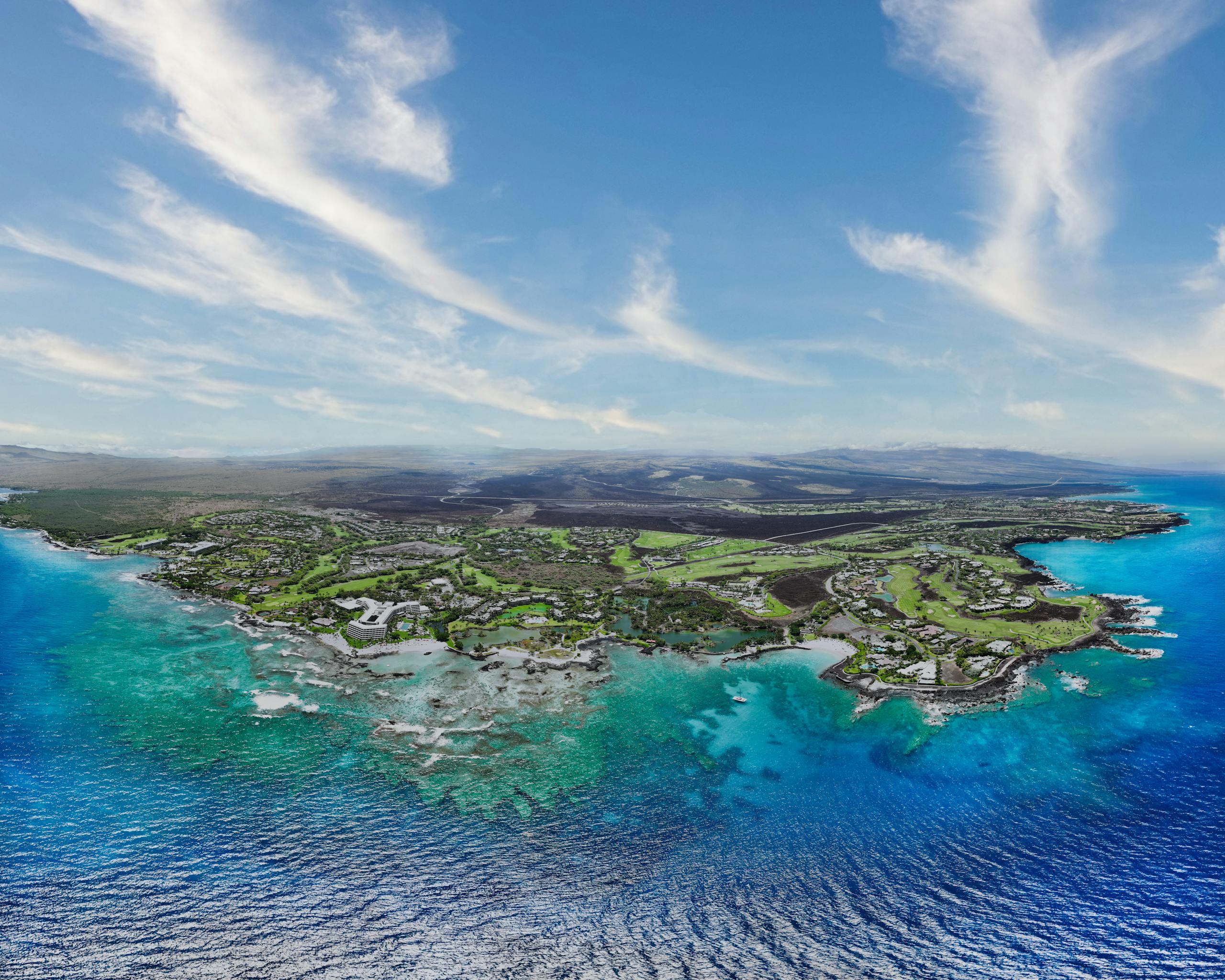 Stunning aerial shot of Waimea coastline, Hawaii, with vibrant turquoise waters and lush landscapes.